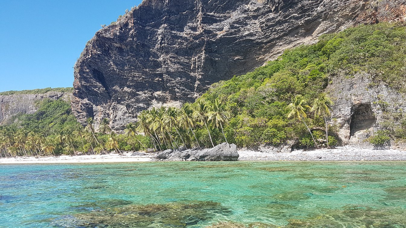 Aerial view of Playa Frontón showing pristine white sand beach surrounded by crystal clear turquoise waters and lush green vegetation